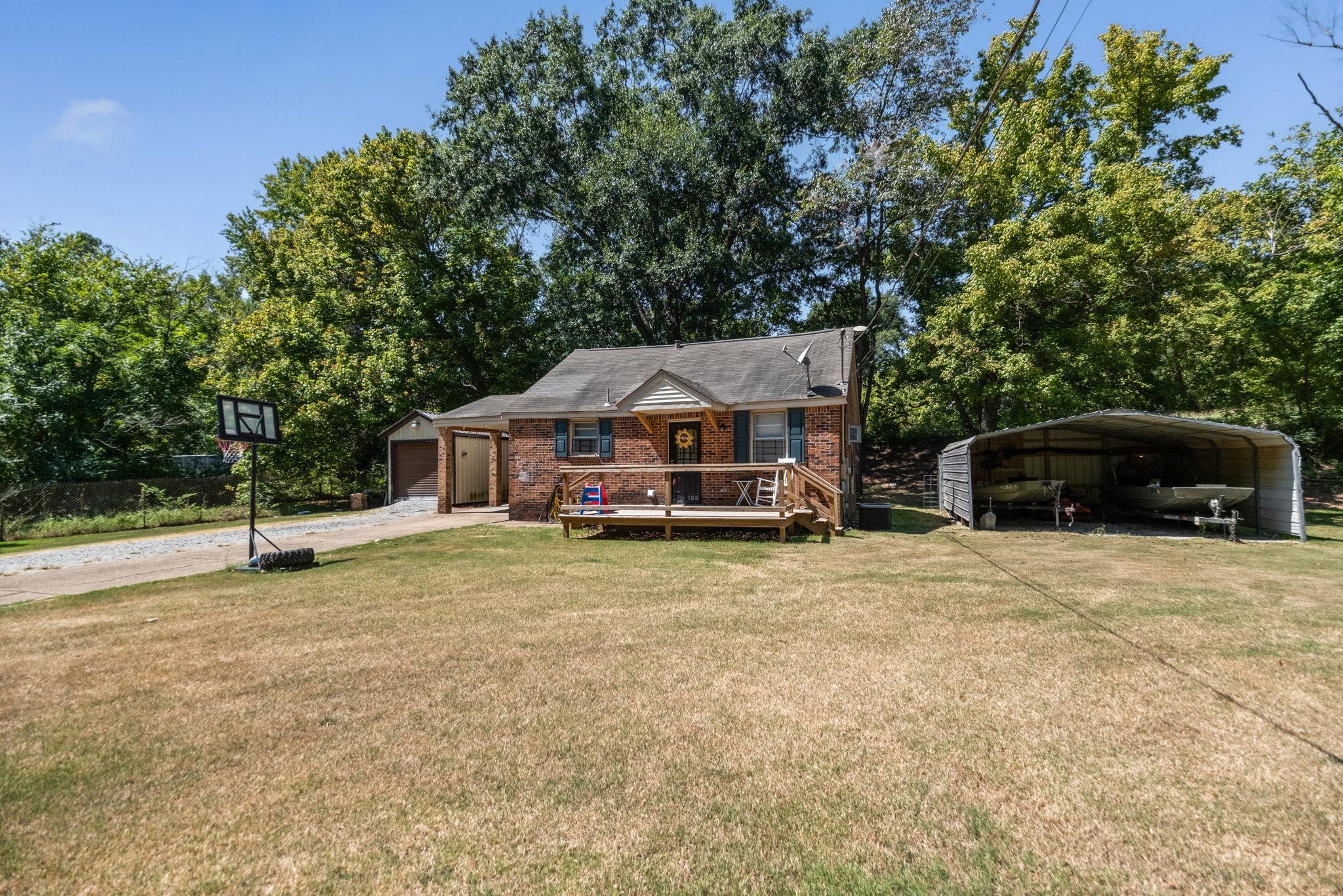 4140 Pleasant Ridge Road Millington, TN 38053 - Photo 24 of 30 View of front of house with a front lawn, brick siding, driveway, view of scattered trees, and a garage