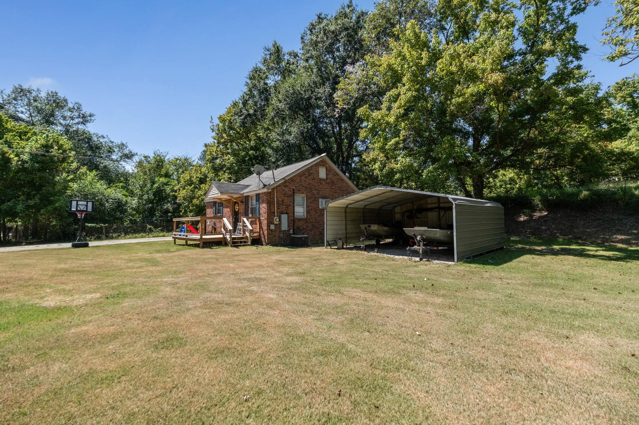 4140 Pleasant Ridge Road Millington, TN 38053 - Photo 26 of 30 Exterior space with a wooden deck, a front yard, a carport, and brick siding