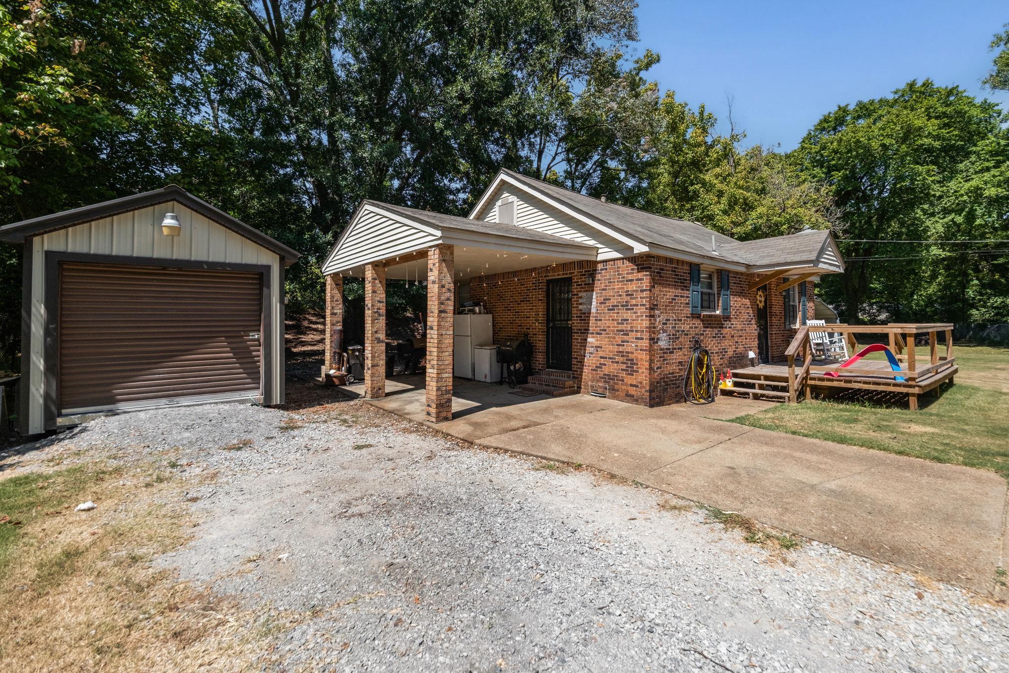 4140 Pleasant Ridge Road Millington, TN 38053 - Photo 29 of 30 View of front facade with driveway, brick siding, an outdoor structure, and a deck