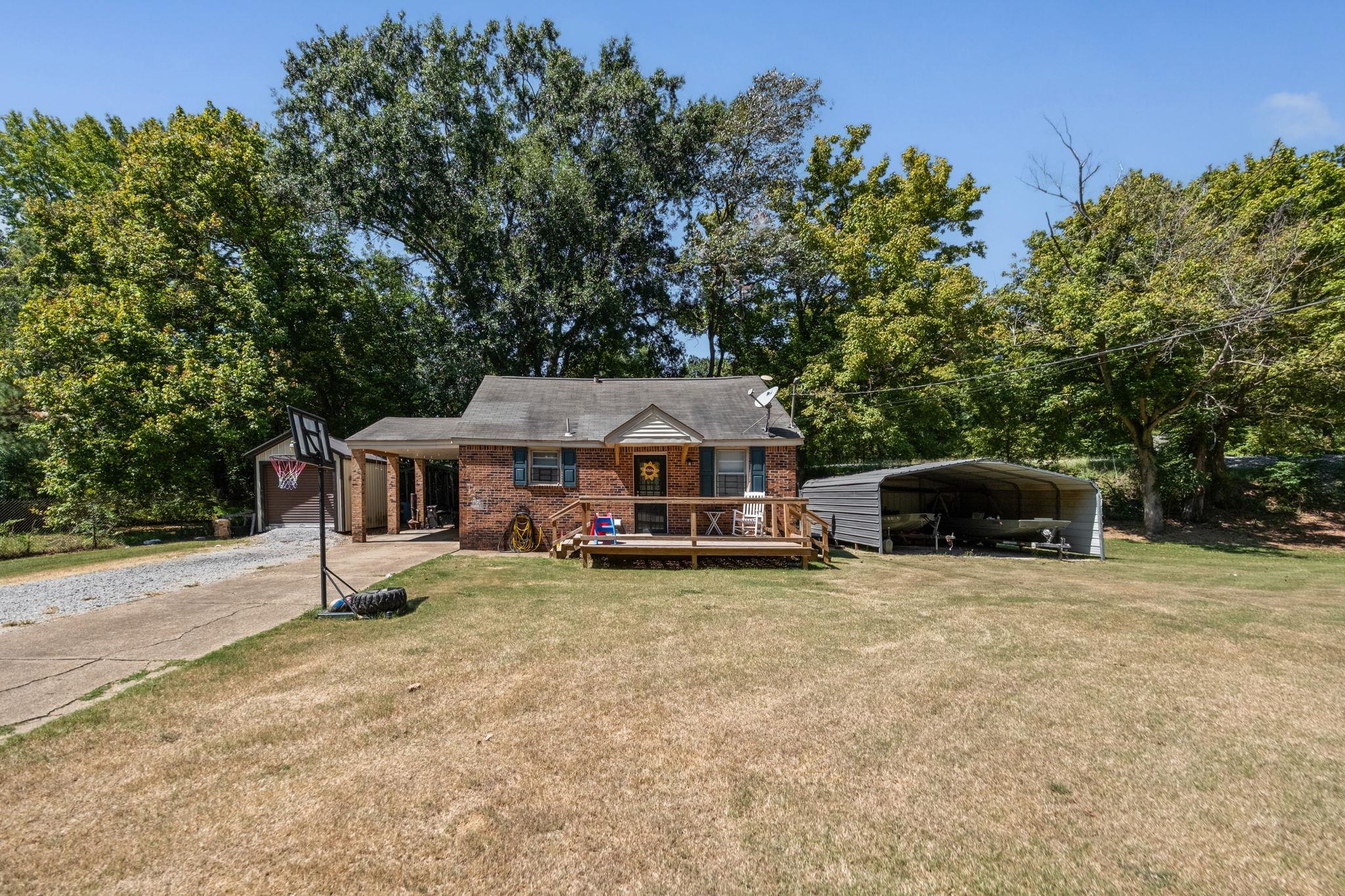 4140 Pleasant Ridge Road Millington, TN 38053 - Photo 30 of 30 View of front of house with a front yard, brick siding, an outdoor structure, a deck, and a carport