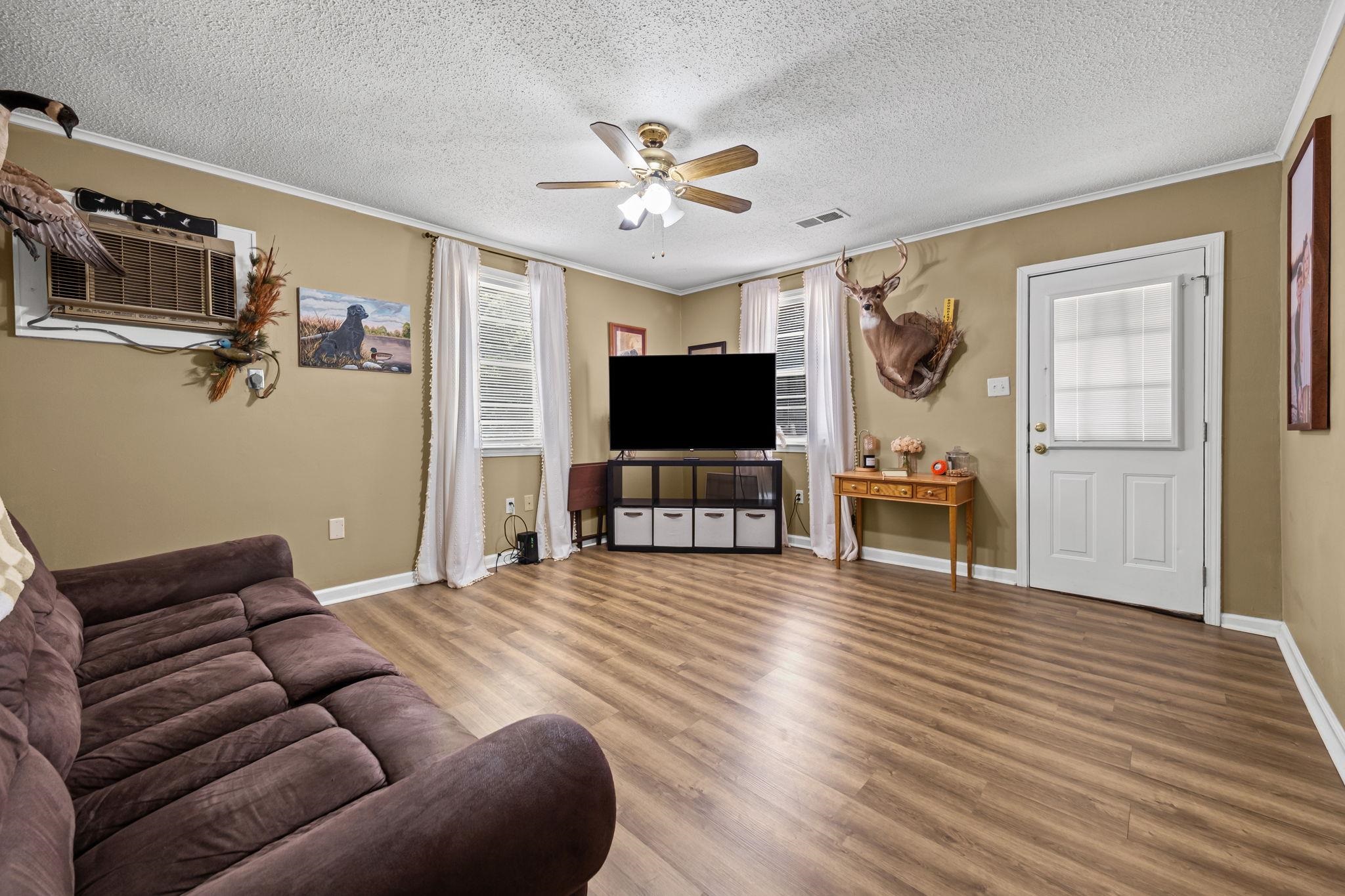 4140 Pleasant Ridge Road Millington, TN 38053 - Photo 3 of 30 Living room with crown molding, wood finished floors, a textured ceiling, ceiling fan, and a wall mounted air conditioner