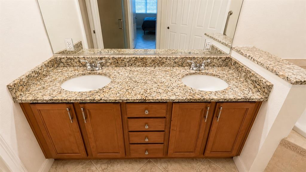 6552 Moorings Point Circle, Unit 102 Lakewood Ranch, FL 34202 - Photo 19 of 57 a bathroom with a granite countertop sink and a mirror