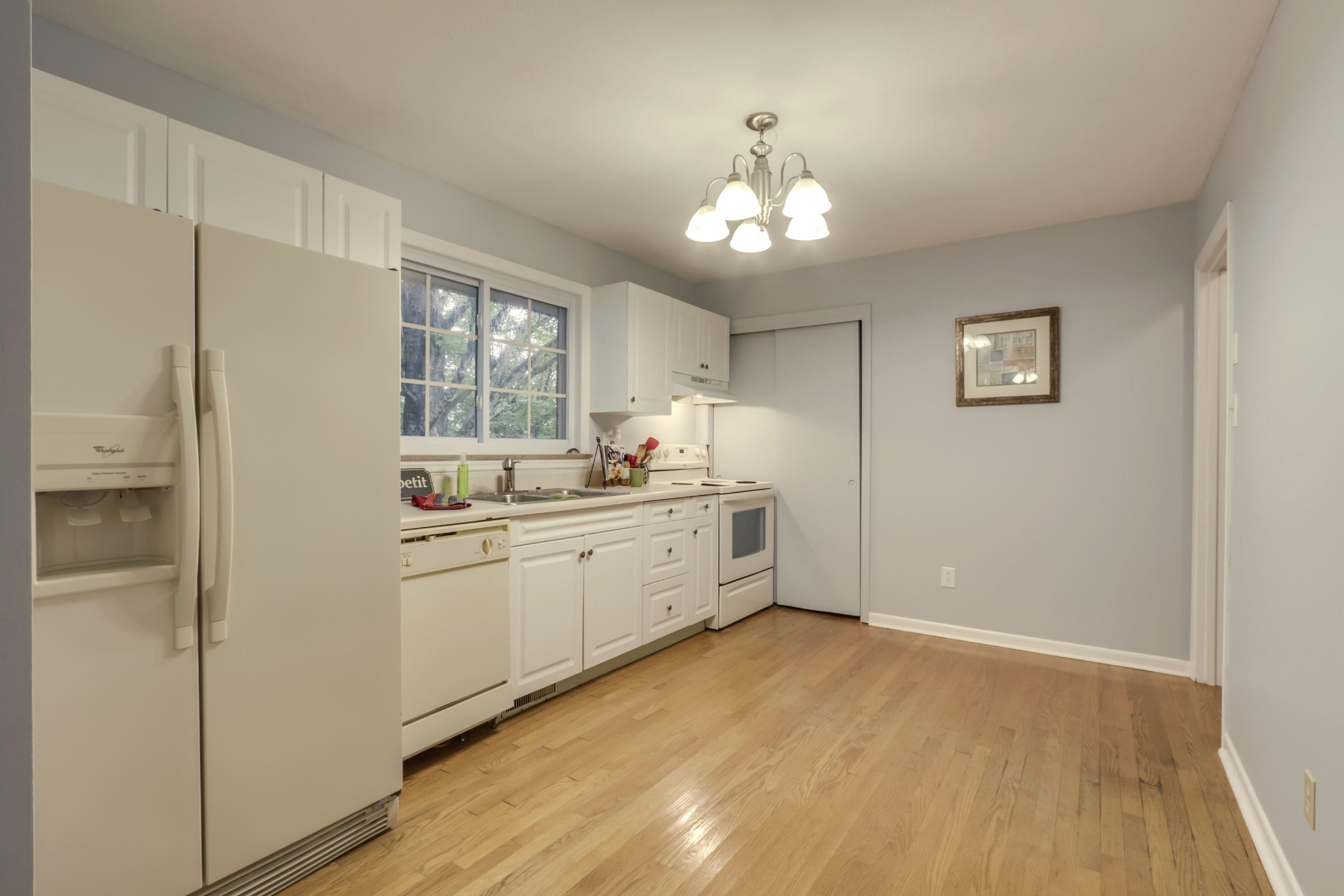 7604 Ogg Road Knoxville, TN 37938 - Photo 23 of 39 a large white kitchen with a refrigerator cabinets and a wooden floor