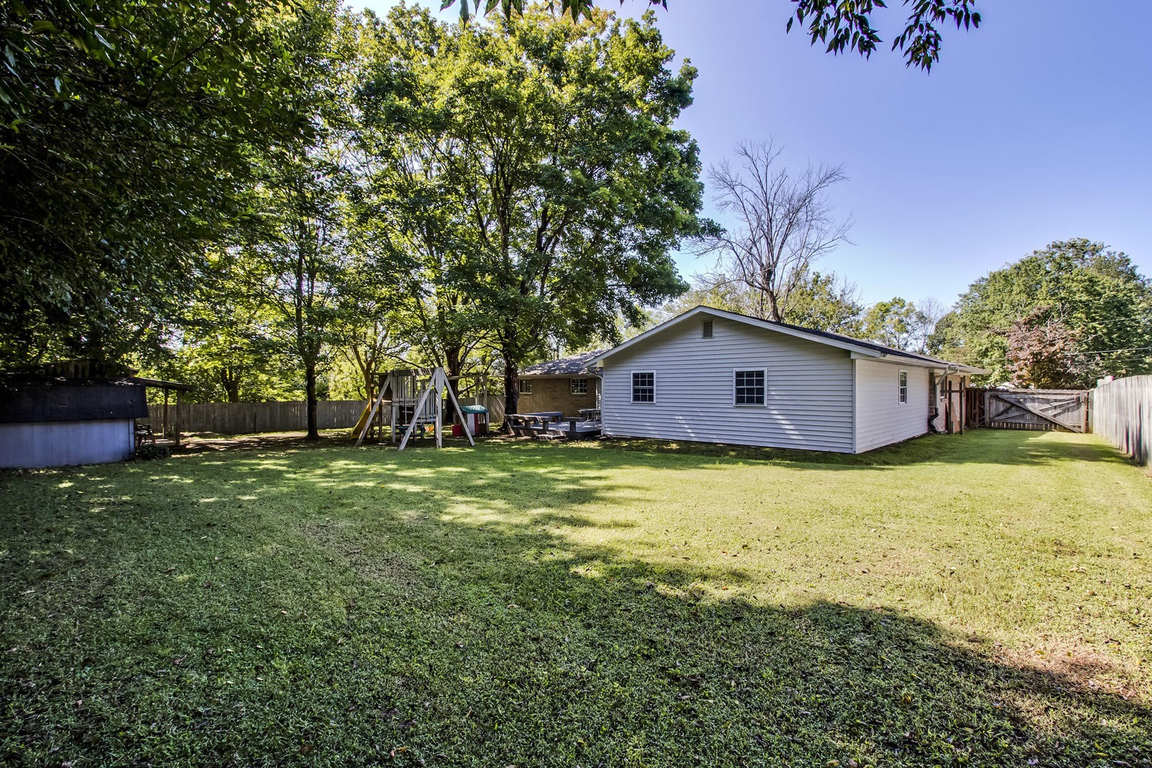 7604 Ogg Road Knoxville, TN 37938 - Photo 6 of 39 a backyard of a house with wooden fence and large trees