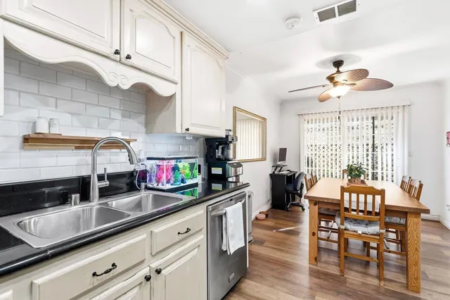 a kitchen with stainless steel appliances granite countertop a sink a stove and a wooden cabinets