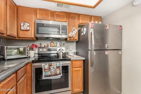 a kitchen with stainless steel appliances granite countertop a refrigerator and a stove