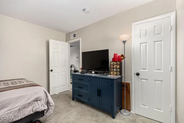 a bedroom with a bed and a flat screen tv