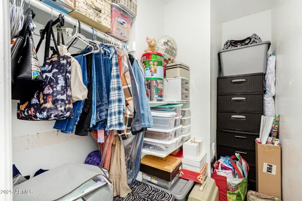 a view of walk in closet with clothes and shoes