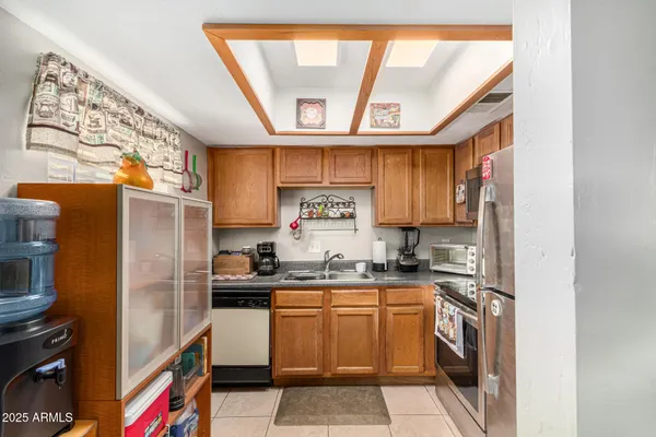 a kitchen with a sink a stove top oven and cabinetry