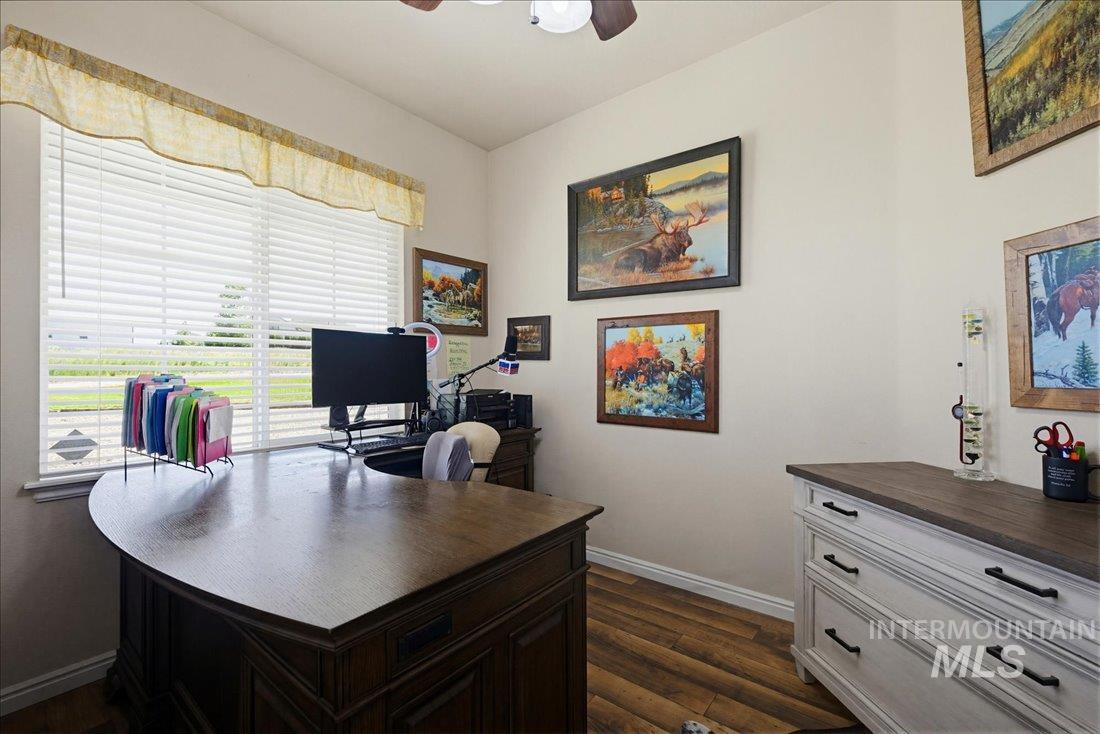 24623 Falcon Lane Caldwell, ID 83607 - Photo 15 of 40 Office space featuring a large window with horizontal blinds, wood-finish flooring, a ceiling fan, and light-toned walls