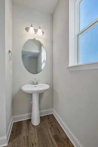 an empty room with wooden floor a ceiling fan a fireplace and windows