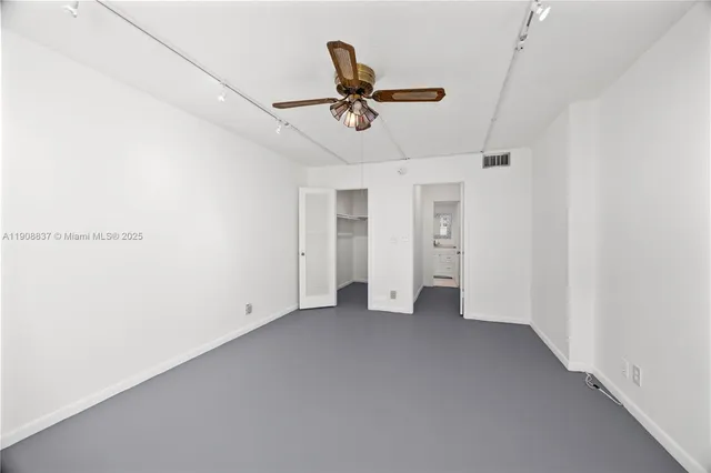 an empty room with closet and windows