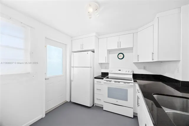 a kitchen with white cabinets and white appliances