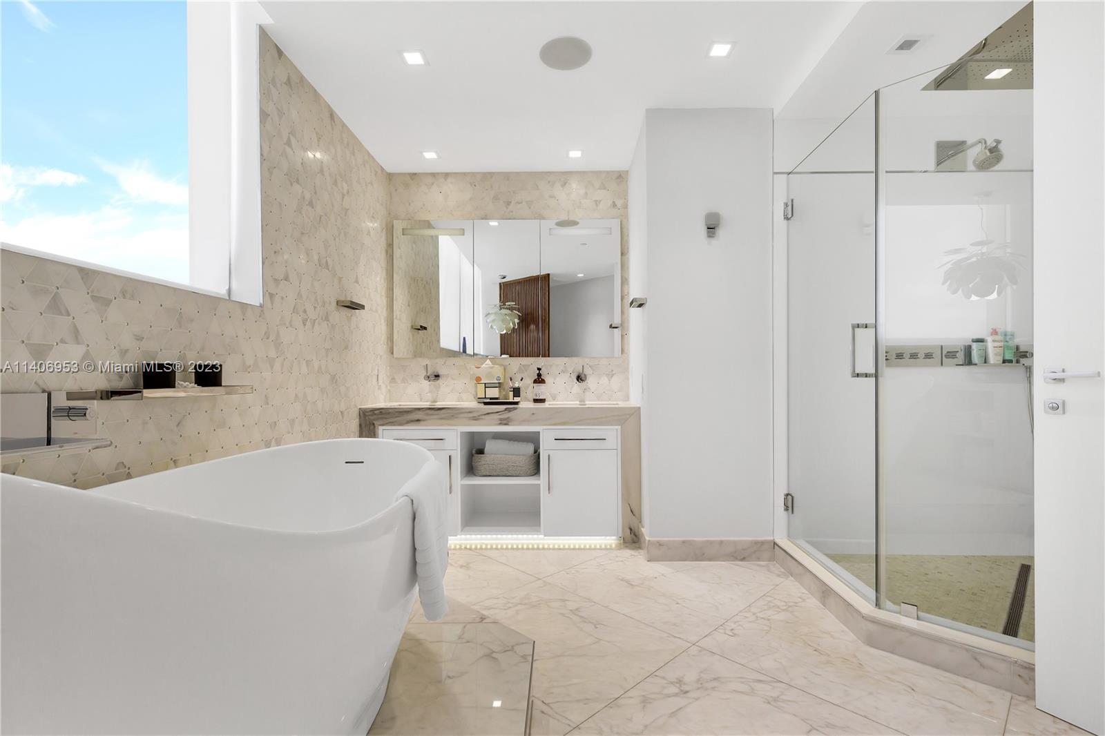 Brickell Miami, FL 33131 - Photo 24 of 41 a bathroom with a tub a sink a mirror and a shower