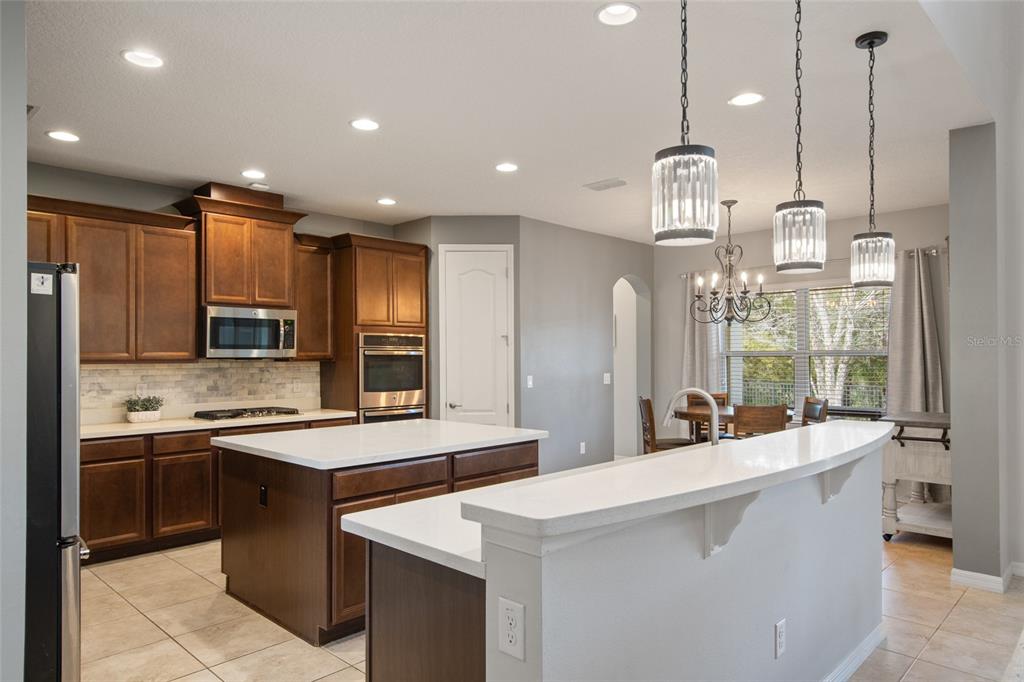 615 Timbervale Trail Clermont, FL 34715 - Photo 23 of 100 a kitchen with stainless steel appliances a sink a stove a refrigerator and chairs