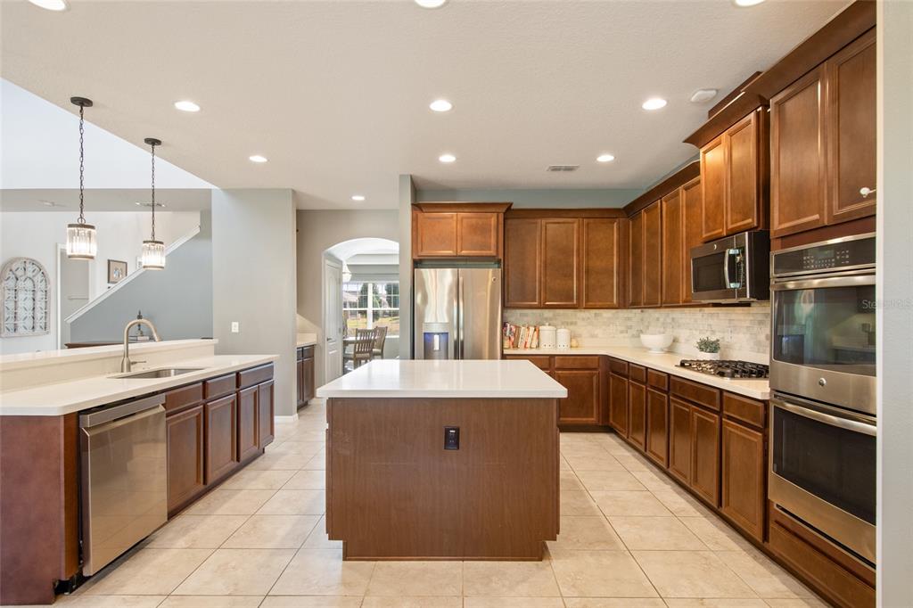 615 Timbervale Trail Clermont, FL 34715 - Photo 26 of 100 a large kitchen with stainless steel appliances kitchen island granite countertop a sink and cabinets