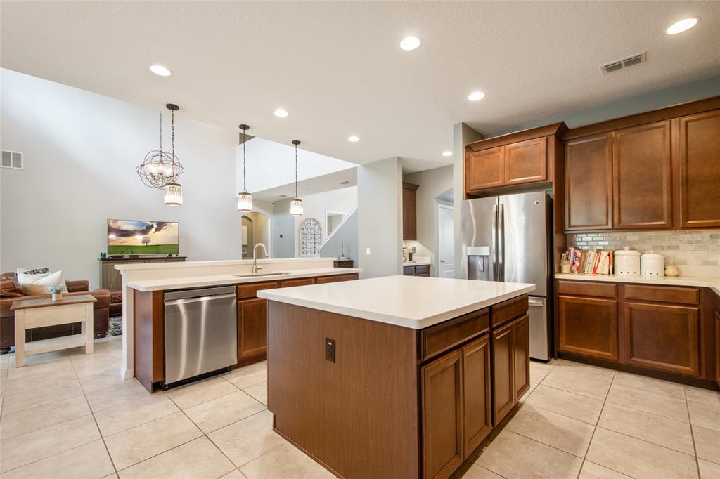 615 Timbervale Trail Clermont, FL 34715 - Photo 29 of 100 a kitchen with stainless steel appliances granite countertop a sink a stove and a refrigerator