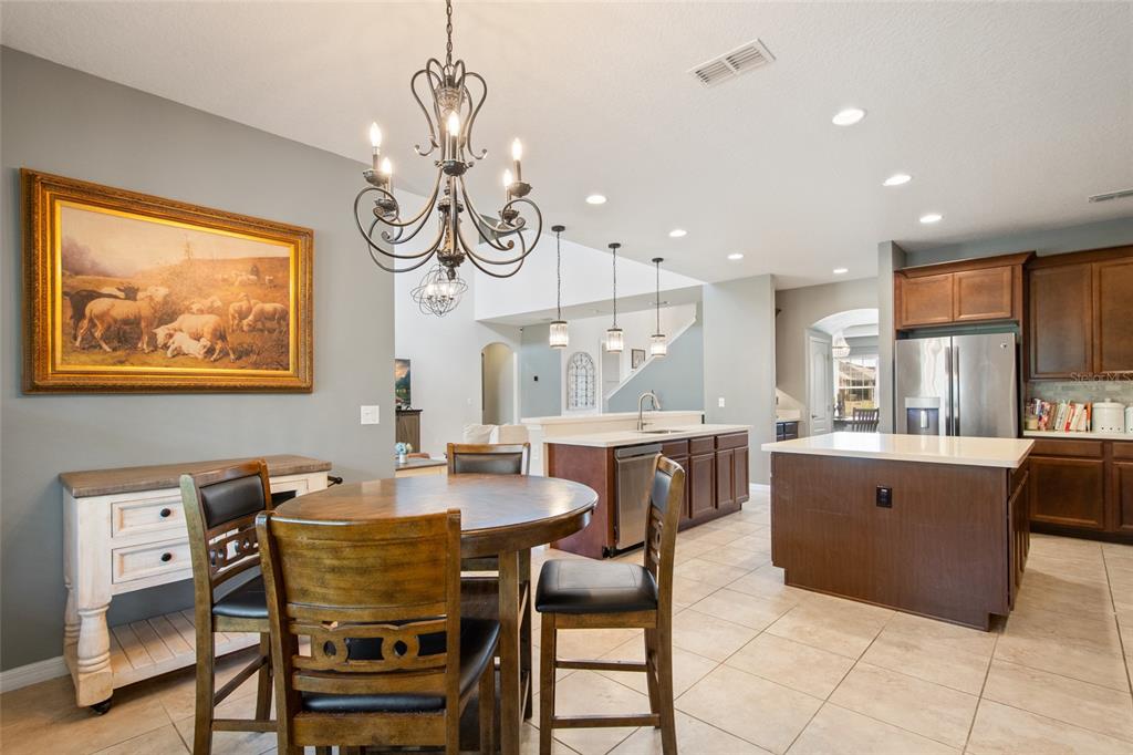 615 Timbervale Trail Clermont, FL 34715 - Photo 32 of 100 a dining room with wooden floor a chandelier a wooden table and chairs