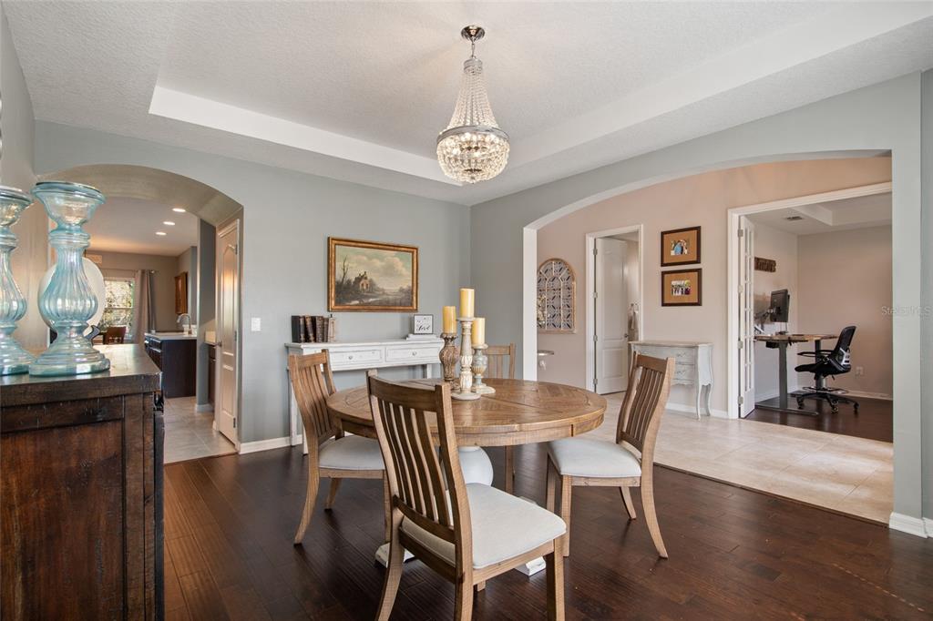 615 Timbervale Trail Clermont, FL 34715 - Photo 8 of 100 a view of a dining room with furniture wooden floor and a chandelier
