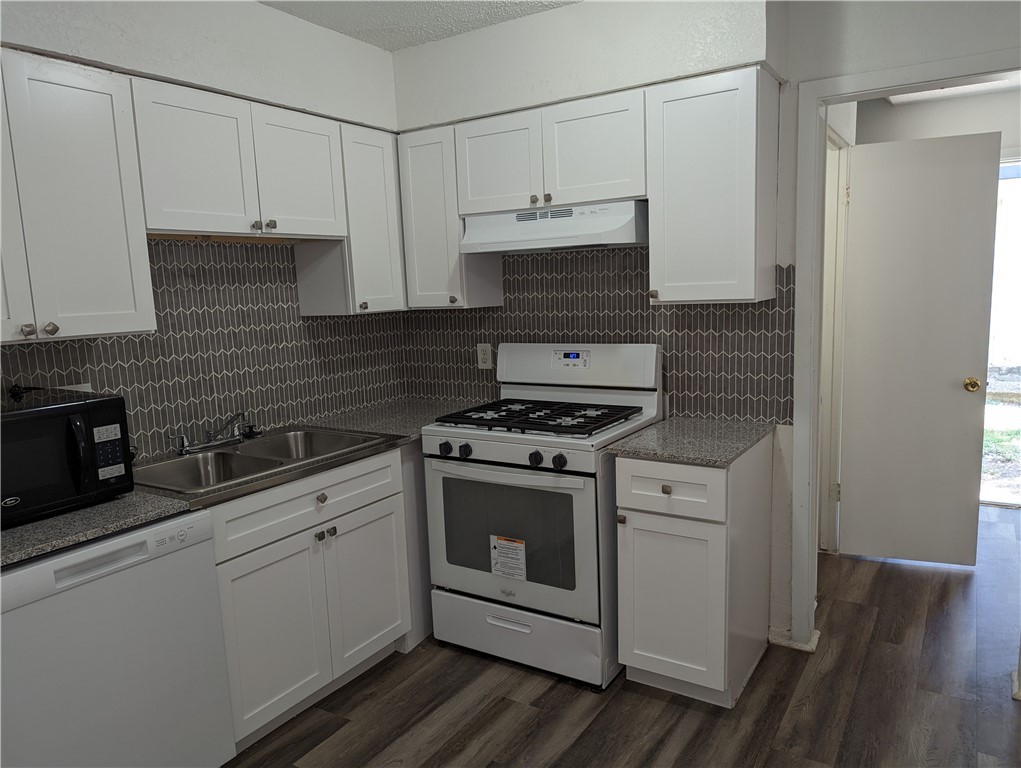 a kitchen with stainless steel appliances white cabinets and white appliances