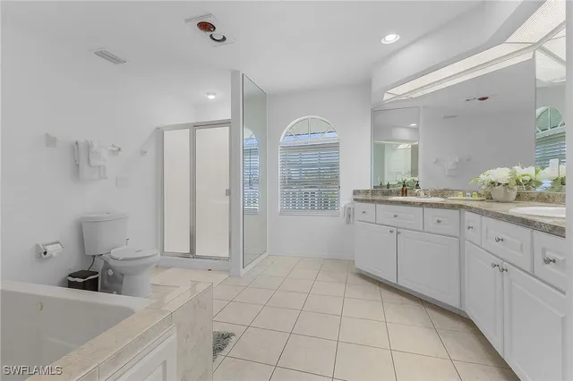 a large white bathroom with a sink a mirror and a bathtub