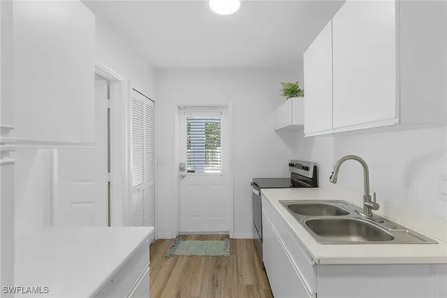 a kitchen with a sink a stove and cabinets