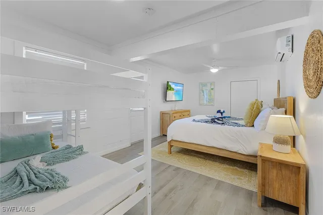 a spacious bedroom with a bed and wooden floor