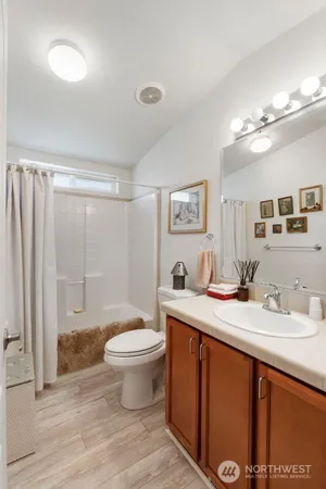 a bathroom with a granite countertop sink a toilet a mirror and shower