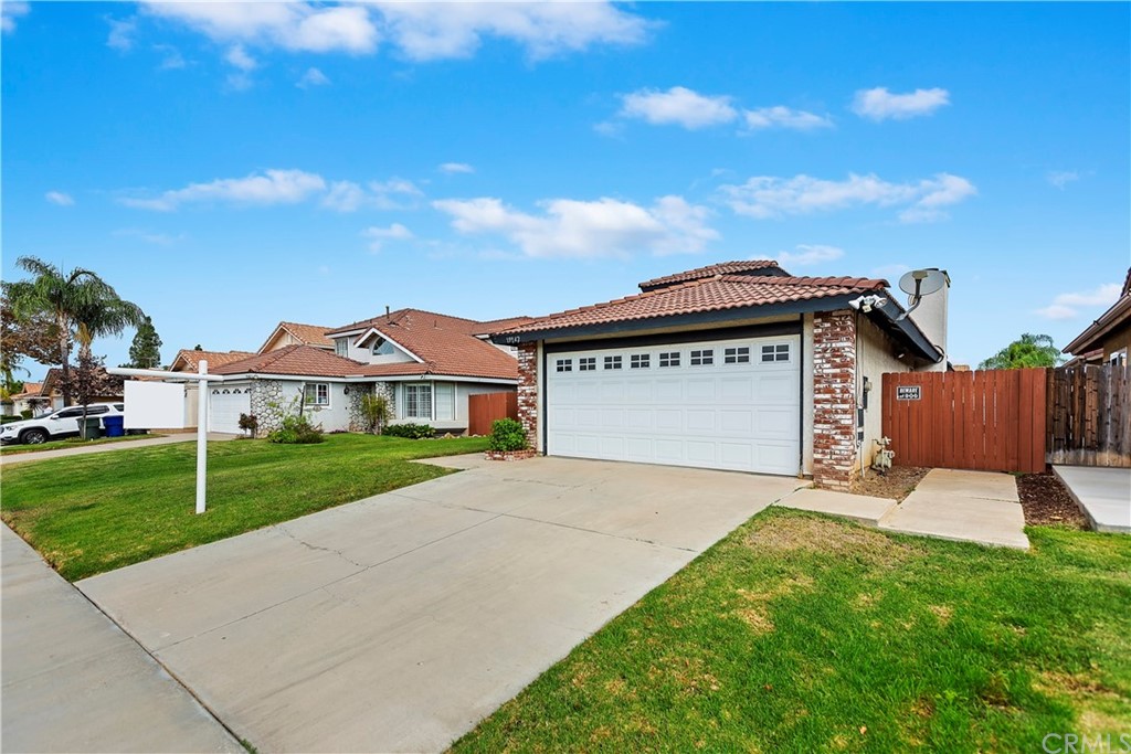 19942 Caraway Lane Riverside, CA 92508 - Photo 1 of 1 a view of a house with a yard and table and chairs under an umbrella