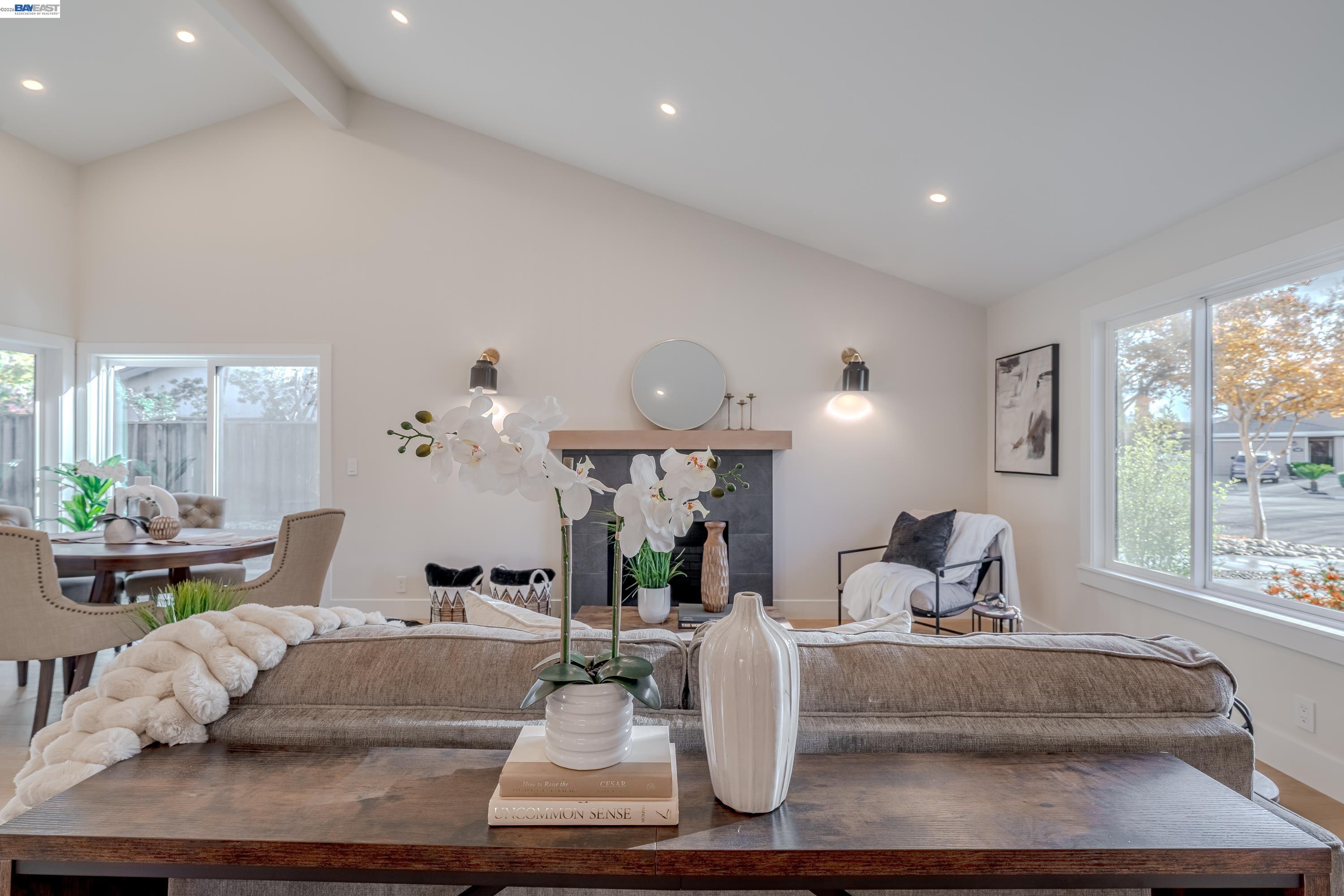 a living room with furniture large window and wooden floor