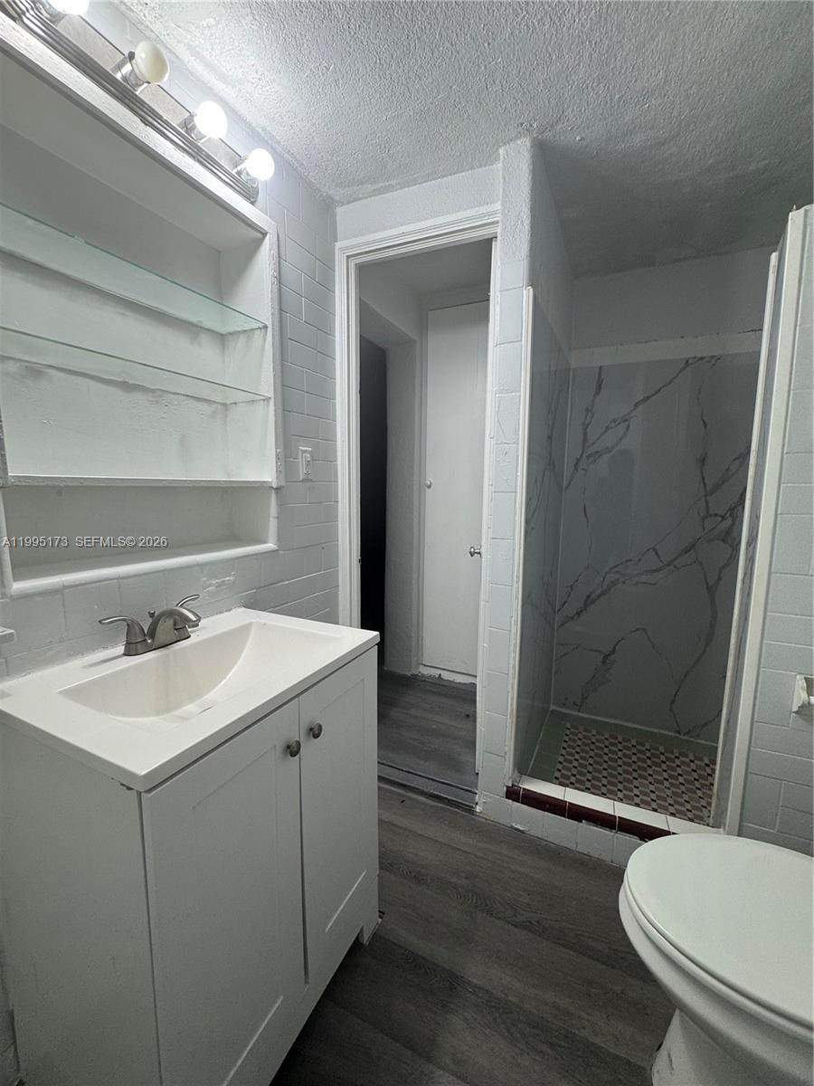 7802 Northwest 8th Avenue, Unit 4 Miami, FL 33150 - Photo 4 of 4 a bathroom with a sink a toilet a mirror and shower