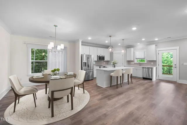 a kitchen with kitchen island granite countertop a stove a sink a refrigerator a center island and wooden floor