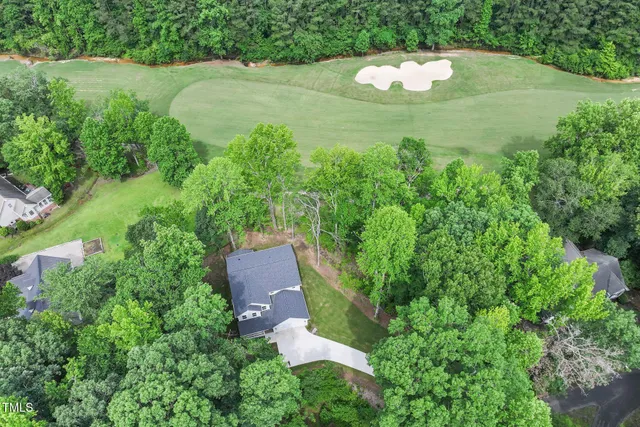 an aerial view of residential house with outdoor space and trees all around