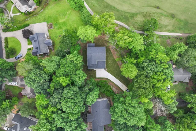 a view of an empty room with wooden floor and a kitchen
