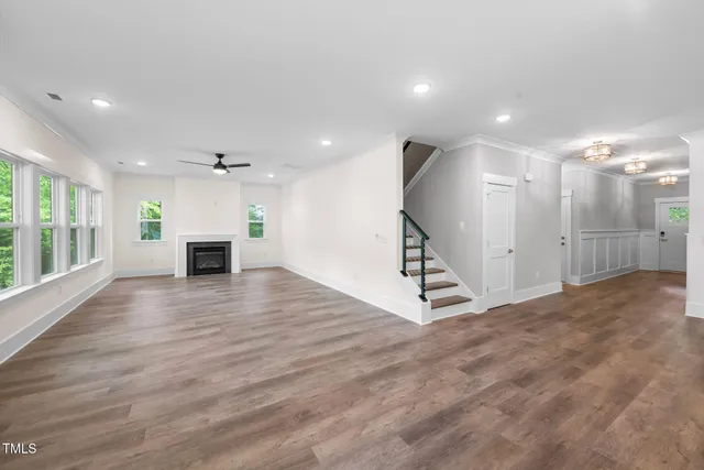 an empty room with windows fireplace and a sink