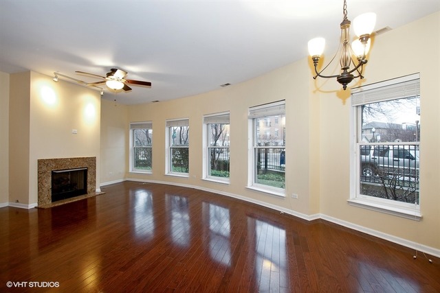 1450 South Halsted Street, Unit 1A Chicago, IL 60607 - Photo 2 of 11 a view of an empty room with wooden floor fireplace and a window