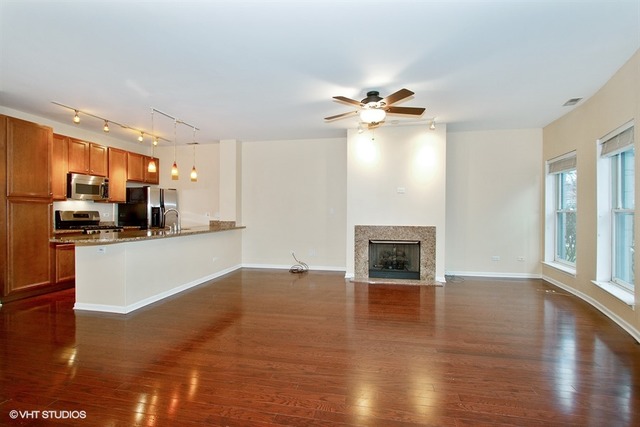 1450 South Halsted Street, Unit 1A Chicago, IL 60607 - Photo 4 of 11 a view of a kitchen with a stove cabinets a fireplace and wooden floor