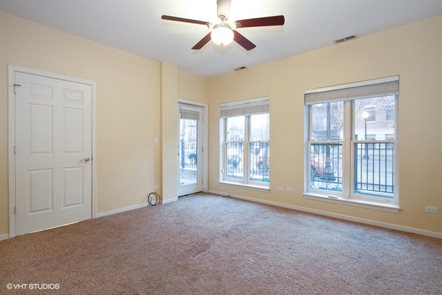 1450 South Halsted Street, Unit 1A Chicago, IL 60607 - Photo 6 of 11 a view of an empty room with a window and a kitchen