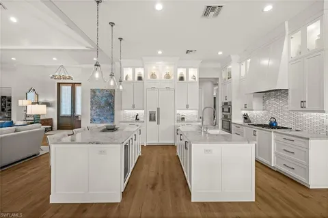 a large white kitchen with lots of counter space wooden floor and appliances