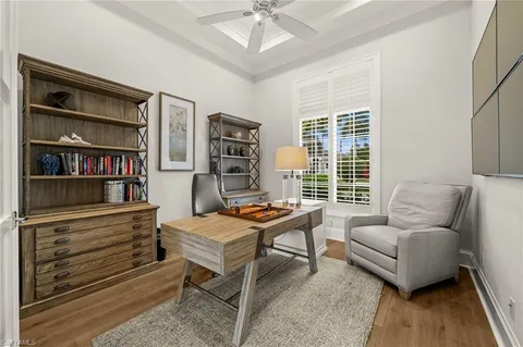 a living room with furniture a bookshelf and a window