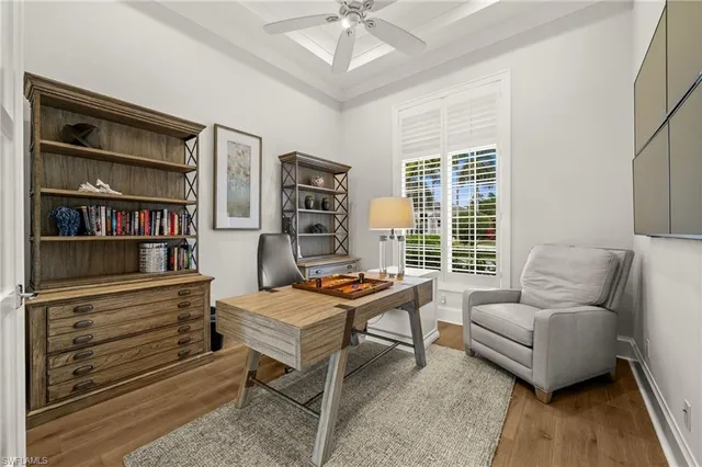 a living room with furniture a bookshelf and a window