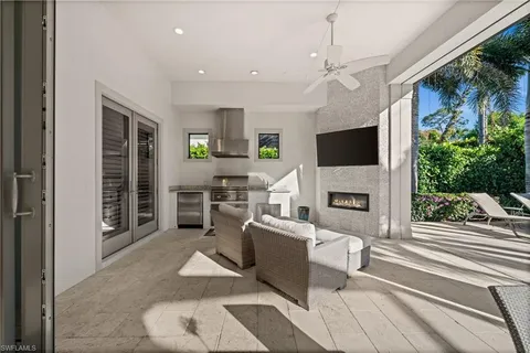 a living room with patio fireplace furniture and a flat screen tv