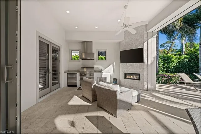a living room with patio fireplace furniture and a flat screen tv