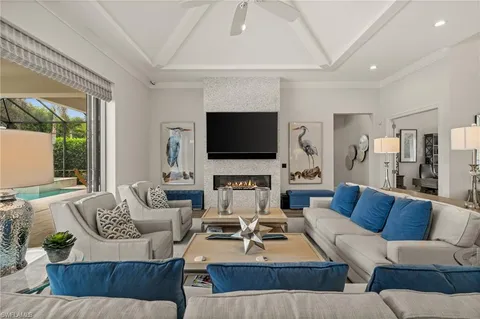 a living room with furniture a large window and a flat screen tv