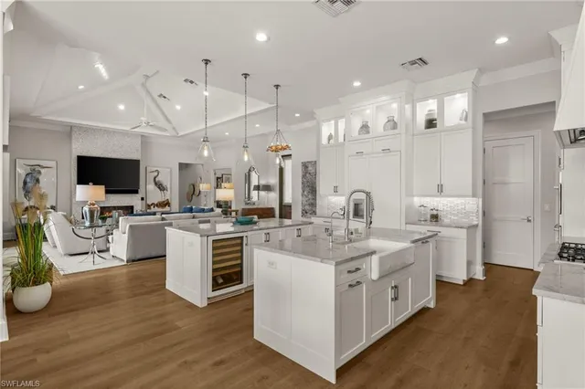 a kitchen with a sink stove and white cabinets with wooden floor