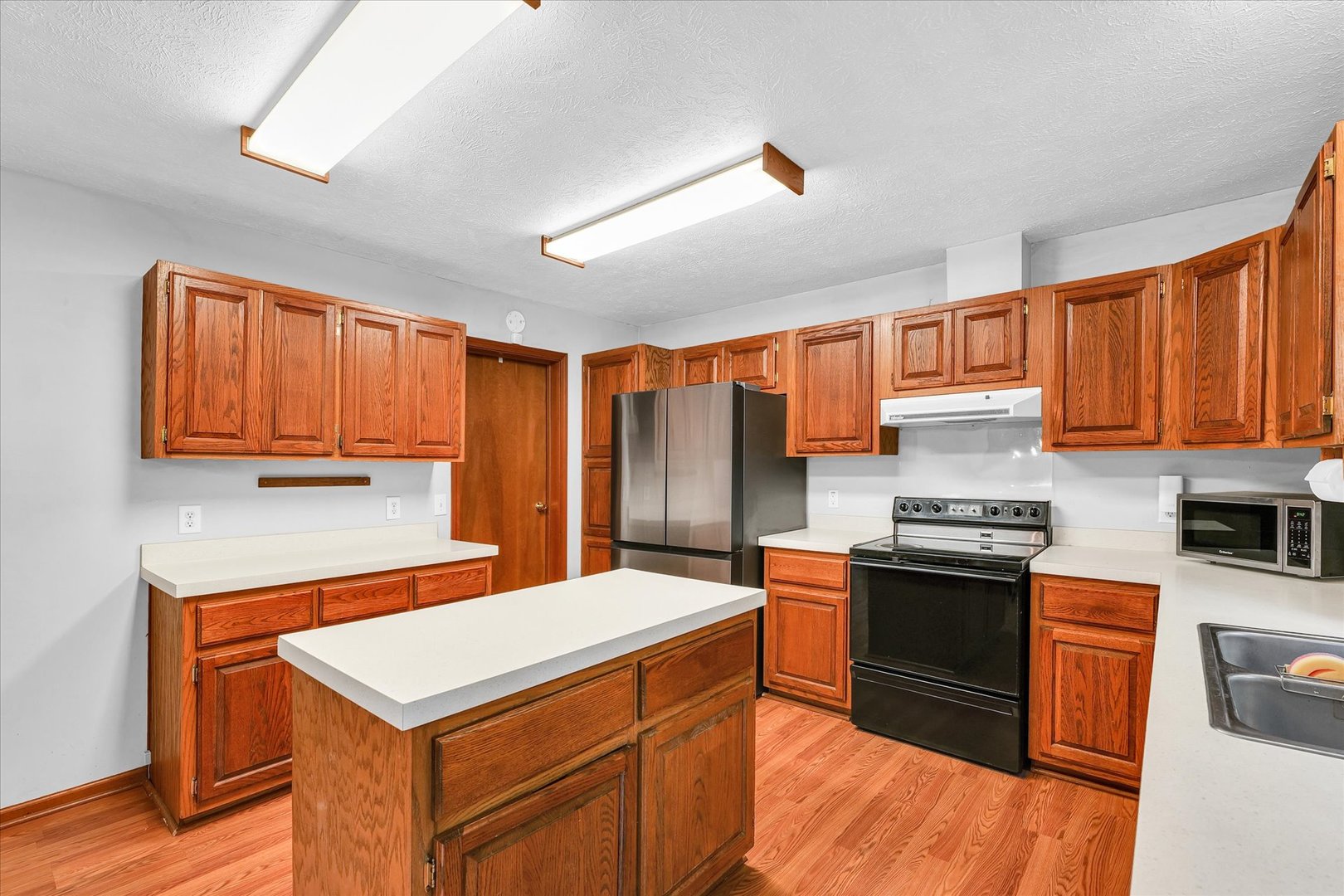 7795 Buttercup Road Weldon, IL 61882 - Photo 14 of 47 a kitchen with stainless steel appliances granite countertop a stove a sink dishwasher and a refrigerator