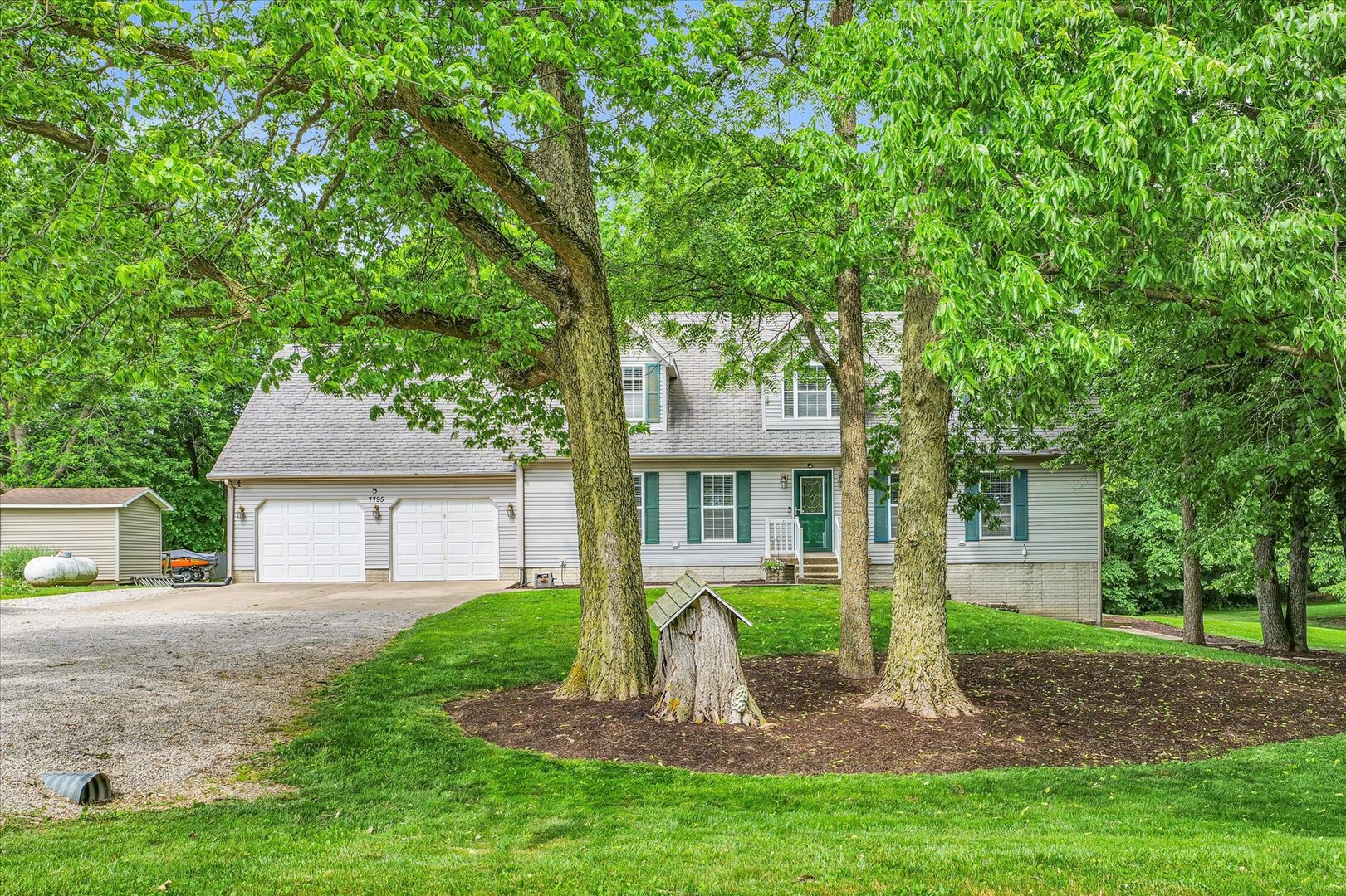 7795 Buttercup Road Weldon, IL 61882 - Photo 4 of 47 a front view of a house with a garden and trees