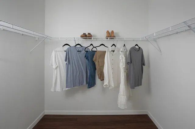 a view of walk in closet with clothes and shoes