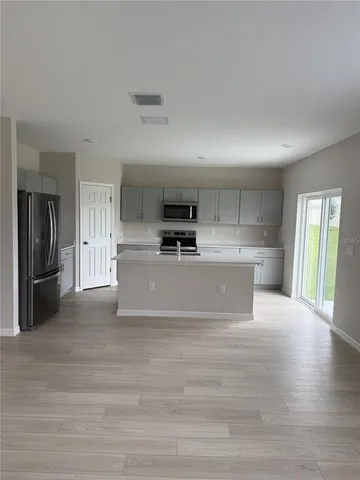 a view of a kitchen with refrigerator stove and cabinets