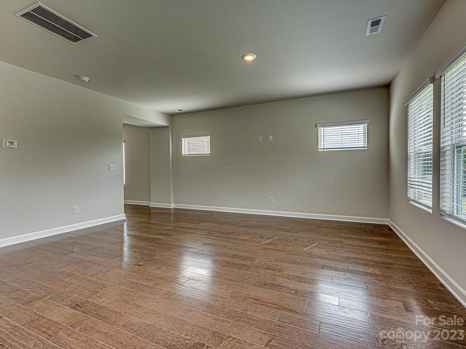 664 Citriadora Street Fort Mill, SC 29715 - Photo 11 of 27 an empty room with wooden floor and windows